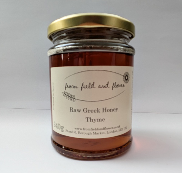 Jar of thyme honey sitting on a white background