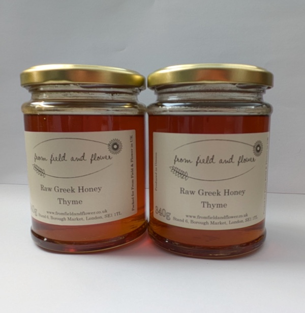 two jars of thyme honey sitting side by side on a white background